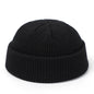 Red knitted beanie cap for men and women, warm woolen skullie hat with simple, solid design for autumn and winter fashion.