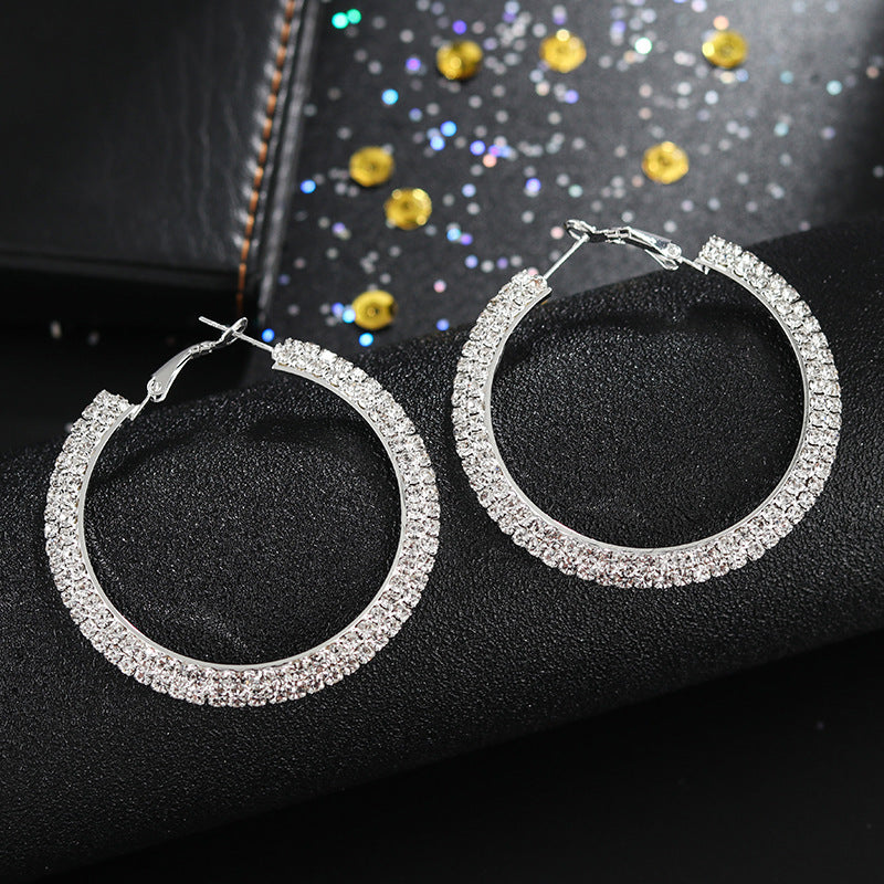 Luxury round crystal hoop earrings for women featuring sparkling crystal embellishments and a sleek, polished metal finish.