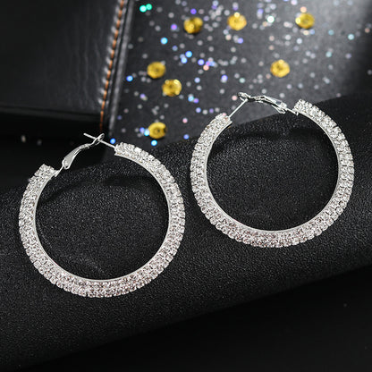 Luxury round crystal hoop earrings for women featuring sparkling crystal embellishments and a sleek, polished metal finish.