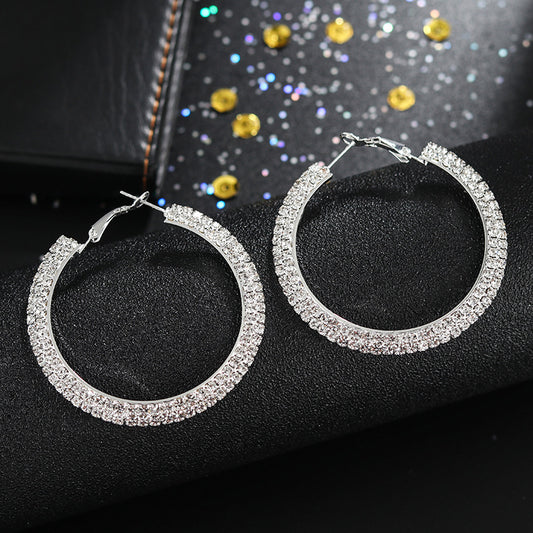 Luxury round crystal hoop earrings for women featuring sparkling crystal embellishments and a sleek, polished metal finish.