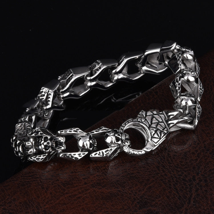 Stainless steel punk skull bracelet with bold design, featuring metallic links and skull accents, on a neutral background.