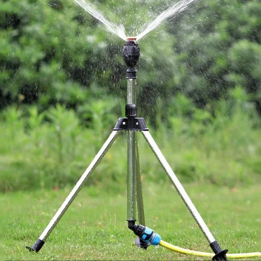 Rotary irrigation sprinkler head on tripod with telescopic support, automatic rotation for garden lawn watering.