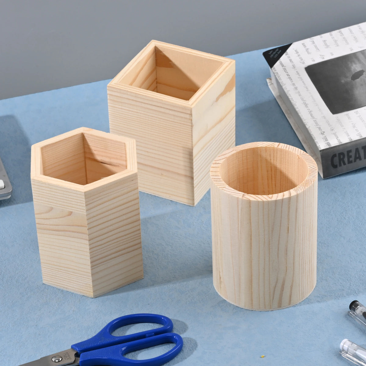 Wooden square, round, and hexagon pencil holder for office desk storage, organizing pens, pencils, and stationery supplies.