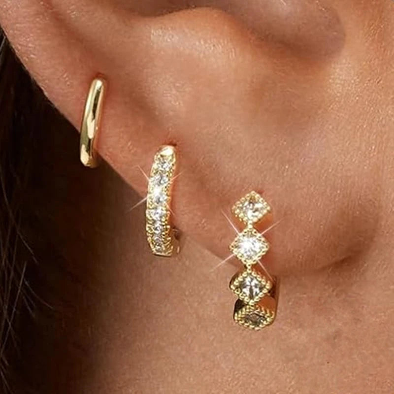 Three pairs of stainless steel zircon huggie hoop earrings for women, featuring delicate small designs and cartilage piercing style.