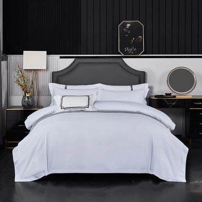 White hotel-style bedding set with duvet cover, sheets, and pillowcases in double, queen, and king sizes, styled on a bed.