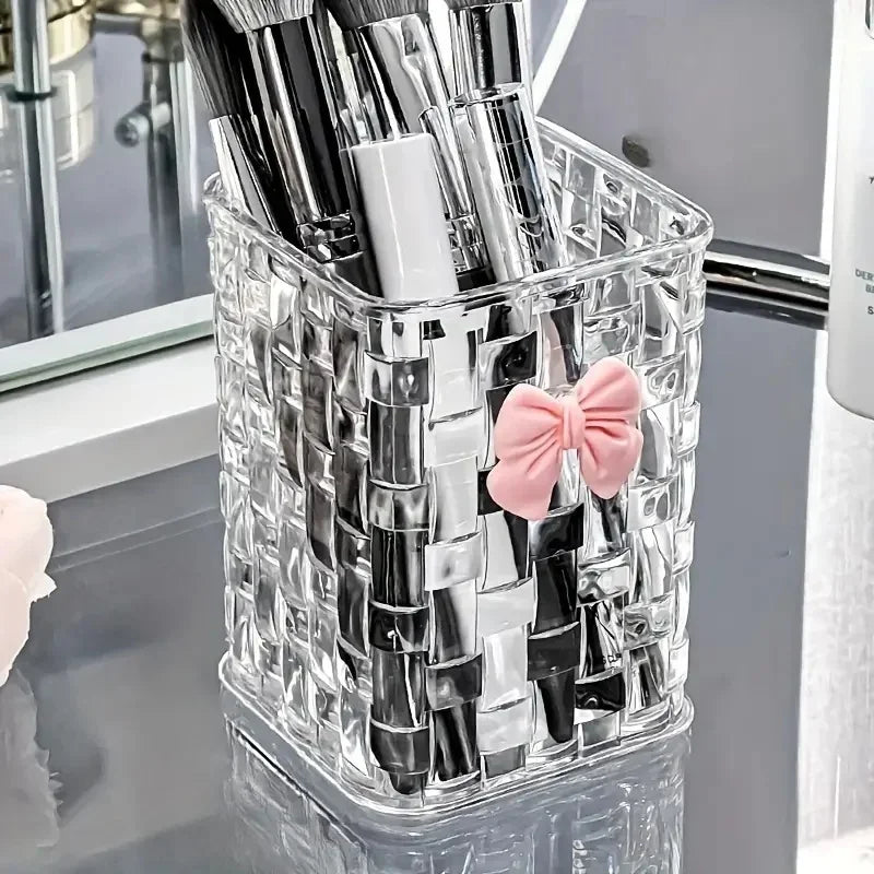 Clear acrylic desk organizer with bow accent, pen holder, and storage basket for office supplies and accessories.