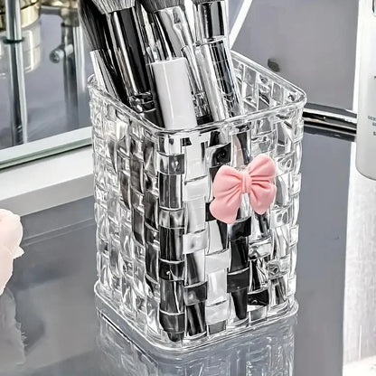 Clear acrylic desk organizer with bow accent, pen holder, and storage basket for office supplies and accessories.