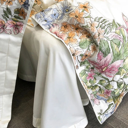 Luxury white Egyptian cotton bedding set with embroidered flowers, including duvet cover, fitted sheet, mattress cover, and pillowcases.