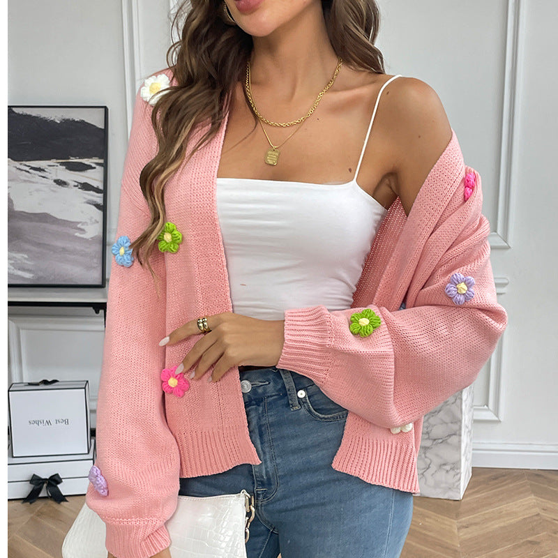 White knitted women's cardigan with floral design, featuring a cozy sweater coat style.