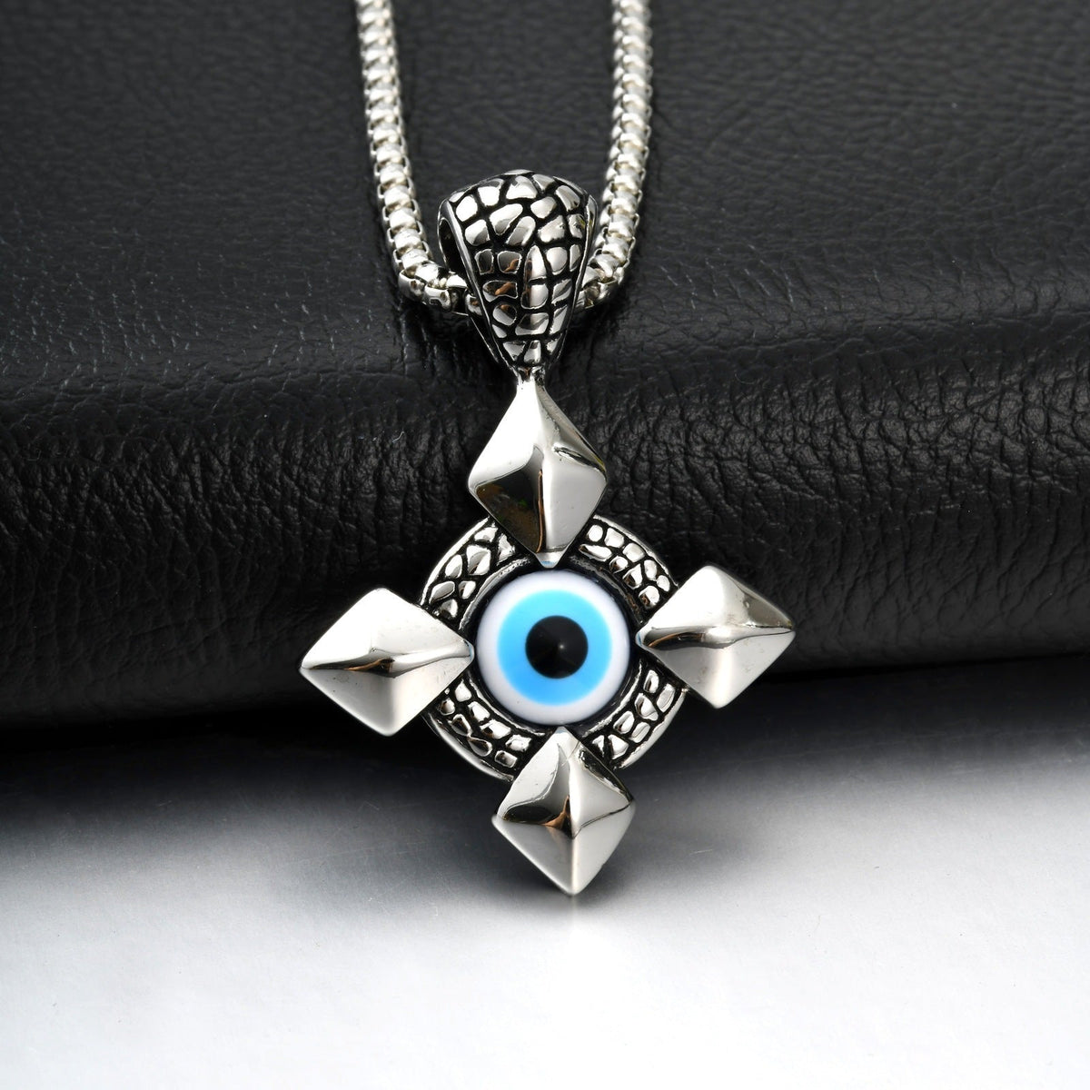 Stainless steel devil’s eye cross pendant necklace with polished metal finish and detailed cross design