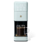 Beautiful Perfect Grind™ Sage Green programmable single-serve coffee maker by Drew Barrymore showing the sleek coffee machine on a countertop.