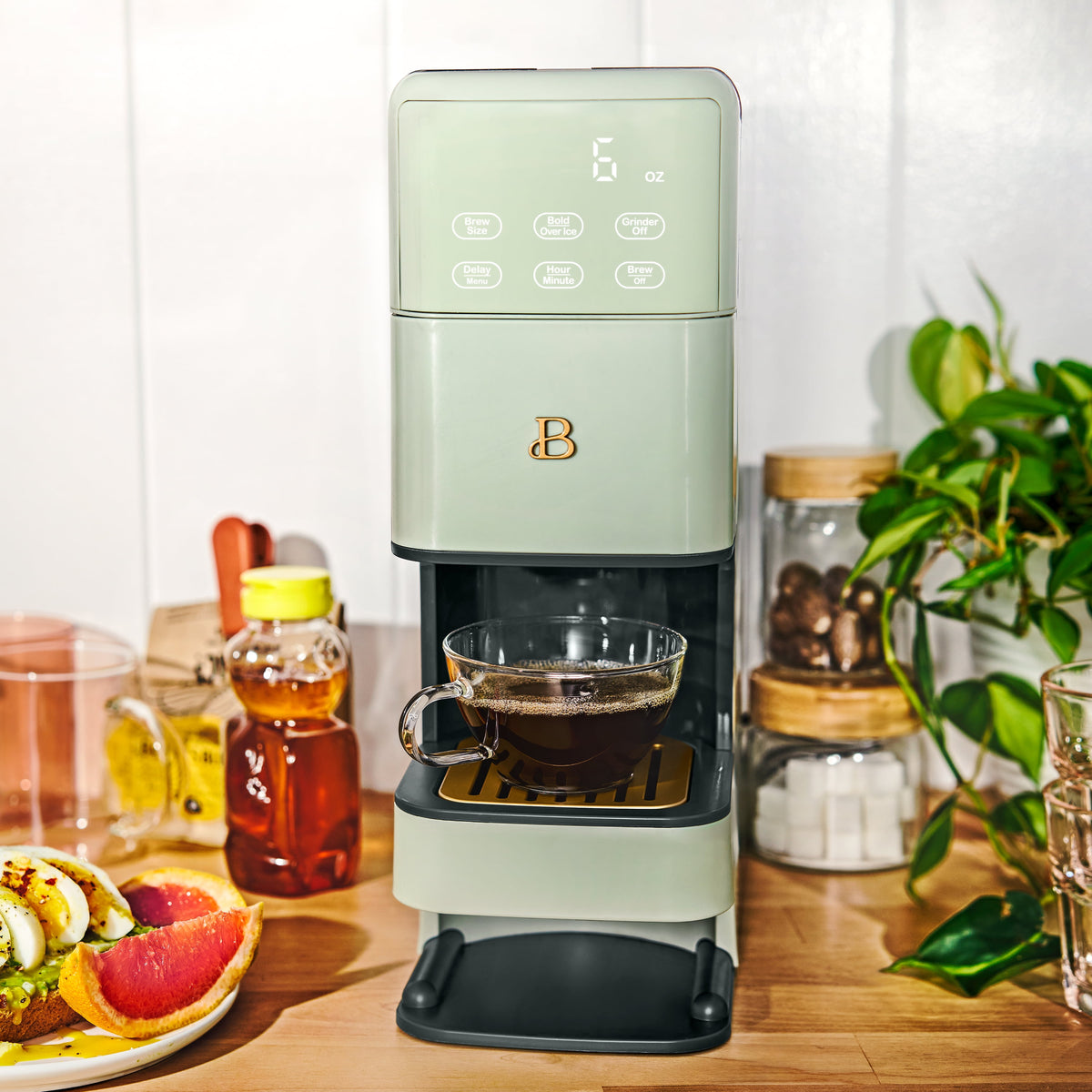 Beautiful Perfect Grind™ programmable single serve coffee maker in sage green by Drew Barrymore, with digital controls and compact design.