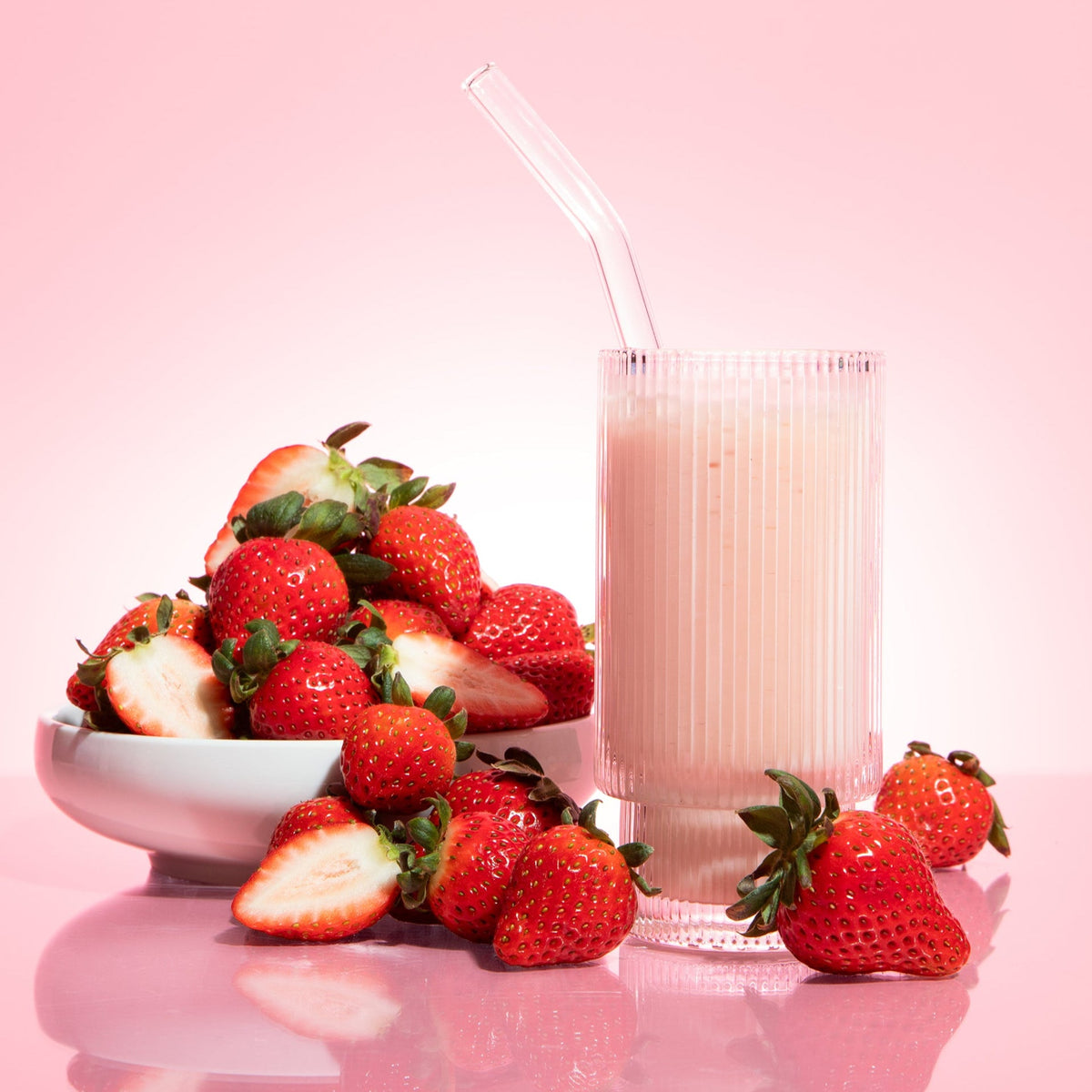 Strawberries and cream flavored Biocare 30G protein dietary beverage powder in a scoop and glass, 14 servings.