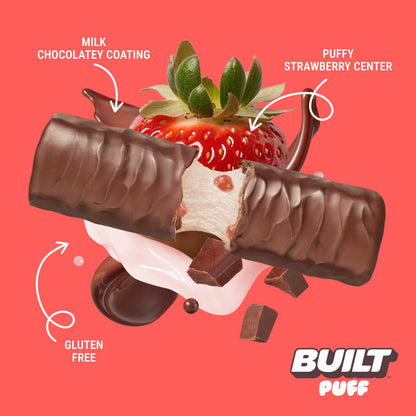 Built Strawberries 'N Cream Puff bar stacked, showcasing the creamy filling and fresh strawberry flavor in a textured snack bar.