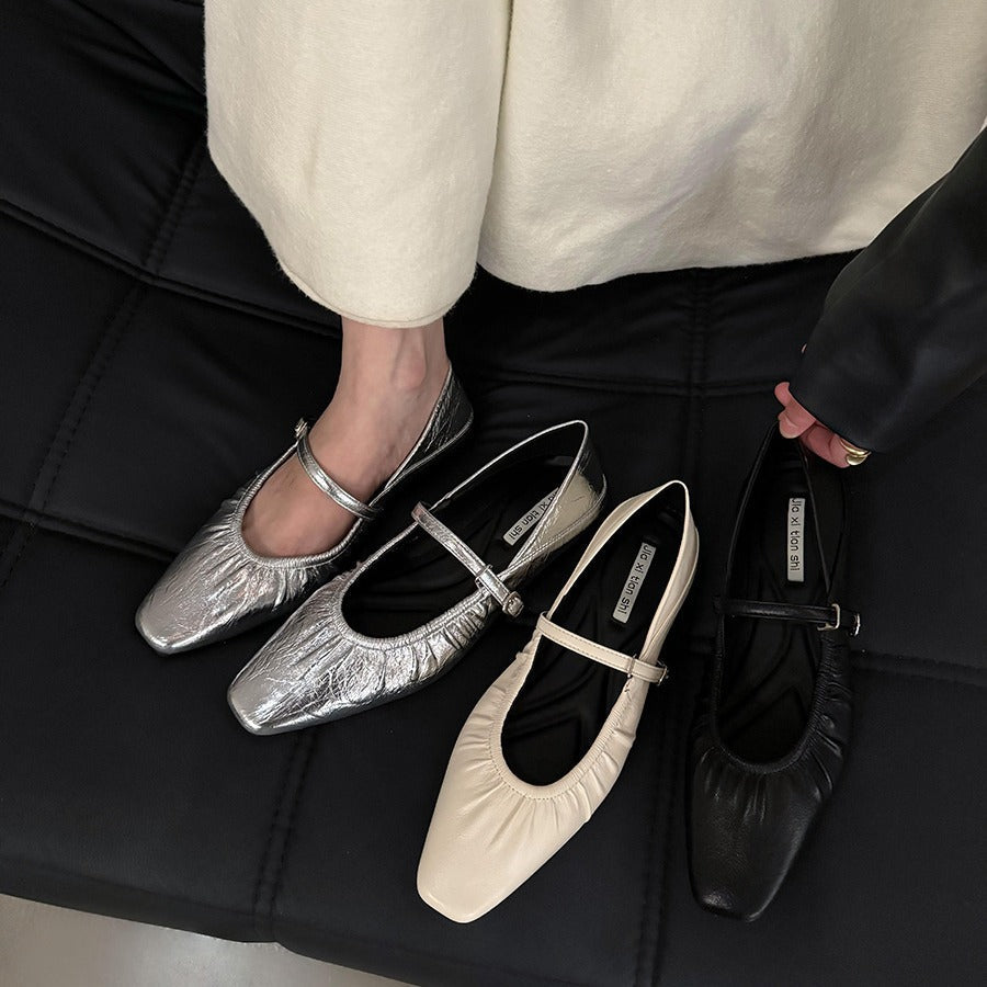 Women's silver flat dress shoes with a sleek, polished finish