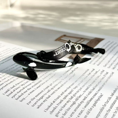 Small decorative orca-shaped glass pendant ornament in a glossy black-and-white design
