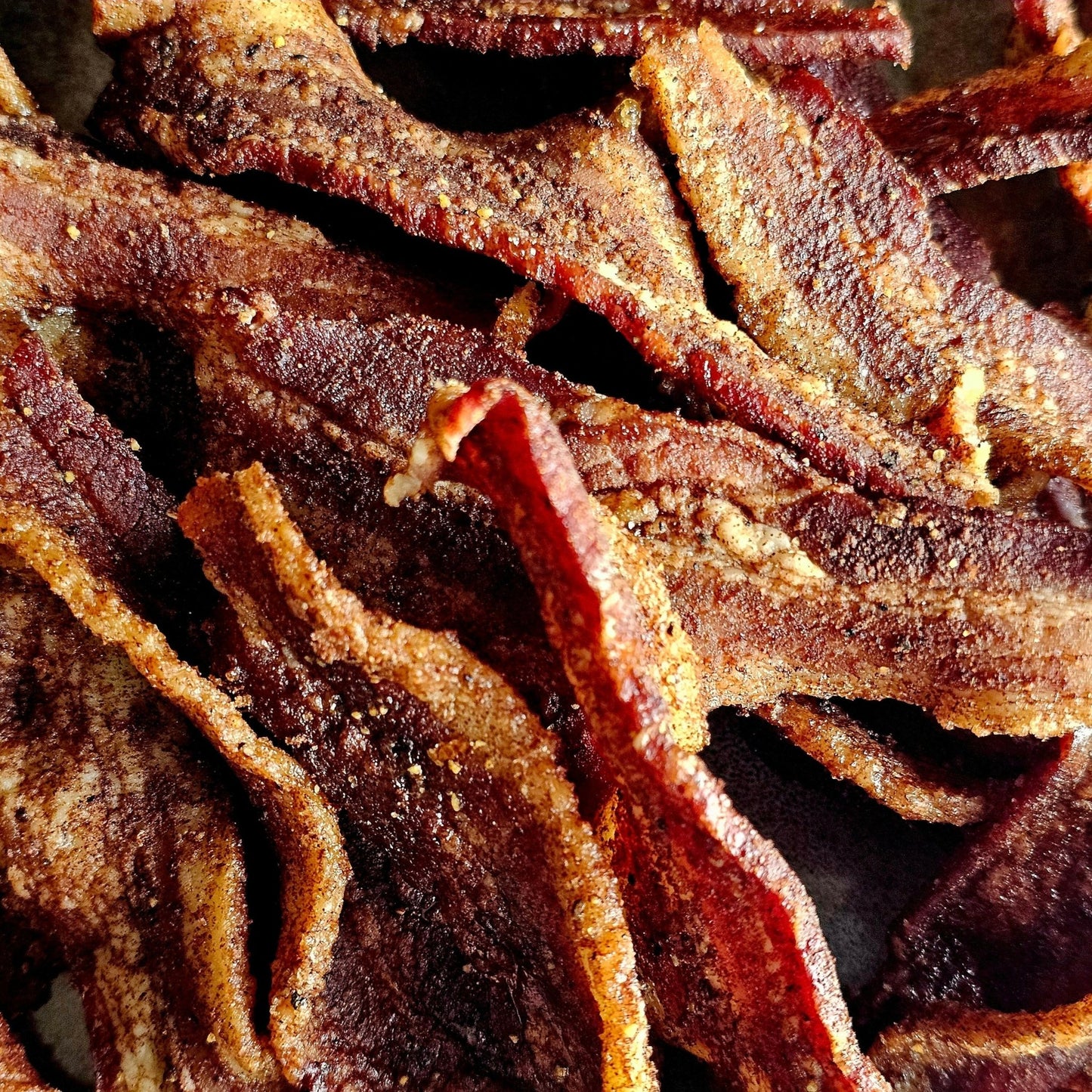 Cedar Valley Cuts Brown Sugar Cinnamon Bacon Jerky in snack size, showcasing glazed bacon slices with cinnamon and brown sugar.
