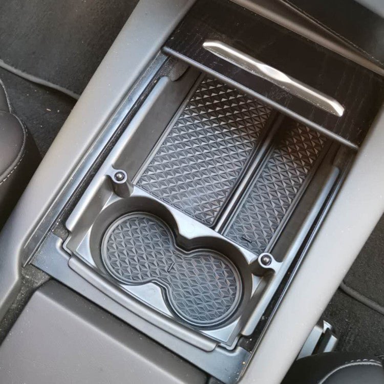 Tesla Model S/X center console armrest storage box, black plastic container for storing small items inside the vehicle.