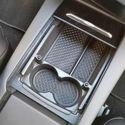 Tesla Model S/X center console armrest storage box, black plastic container for storing small items inside the vehicle.