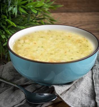 A bowl of chicken pasta soup with tender chicken, pasta, and vegetables in a savory broth, served in a white bowl