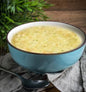 A bowl of chicken pasta soup with tender chicken, pasta, and vegetables in a savory broth, served in a white bowl