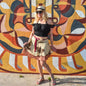 Knee-length Made With Love sari wrap skirt by Darn Good Yarn in warm tones, showcasing a vibrant, patterned Indian-inspired clothing accessory.