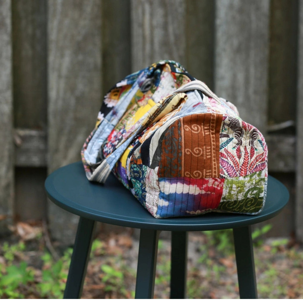 Patchwork quilted duffle bag from Darn Good Yarn, stylish accessories with colorful fabric patchwork and sturdy handles.