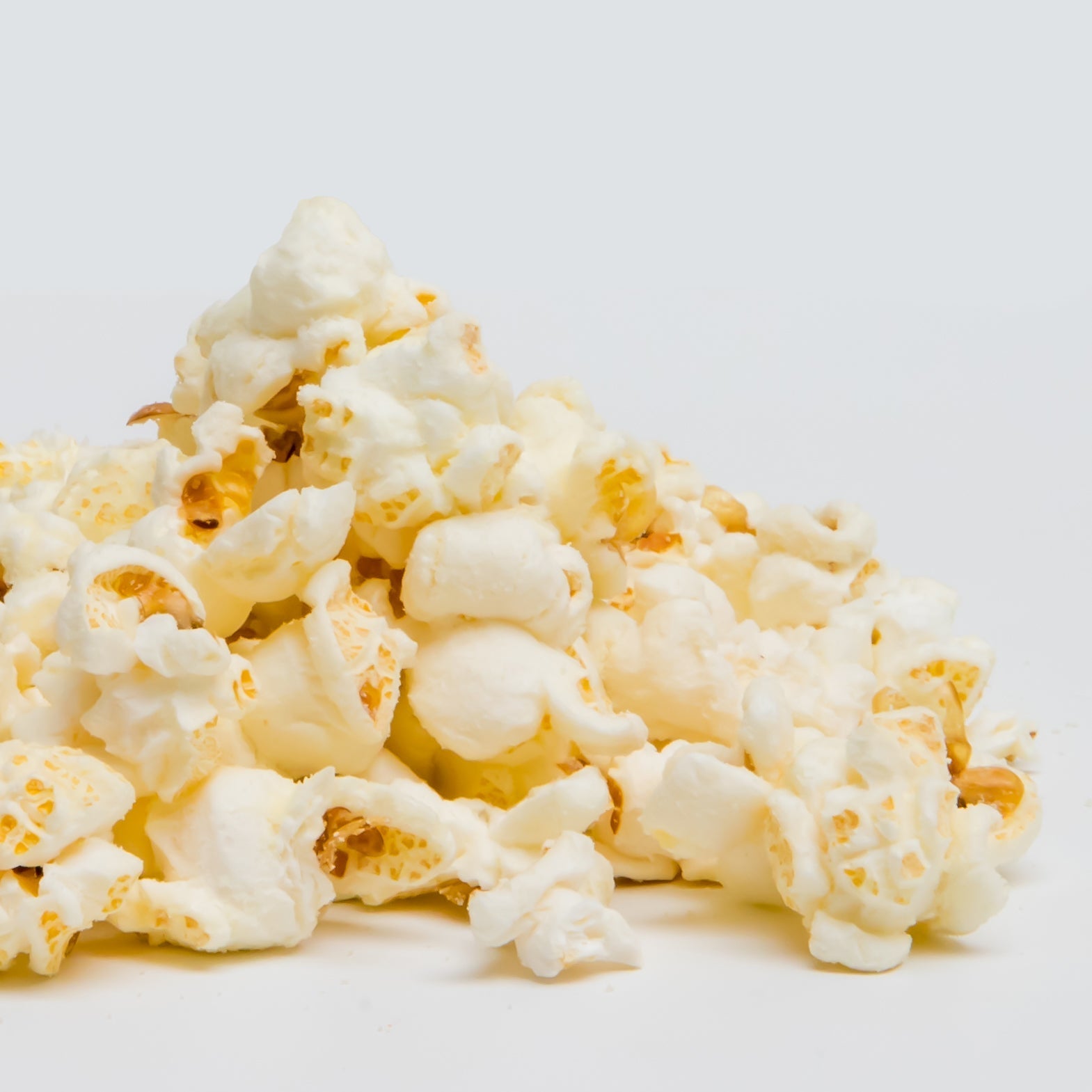White cheddar popcorn by Colorado Popcorn Company in a 2 oz bag, showing crispy, cheesy popcorn kernels.