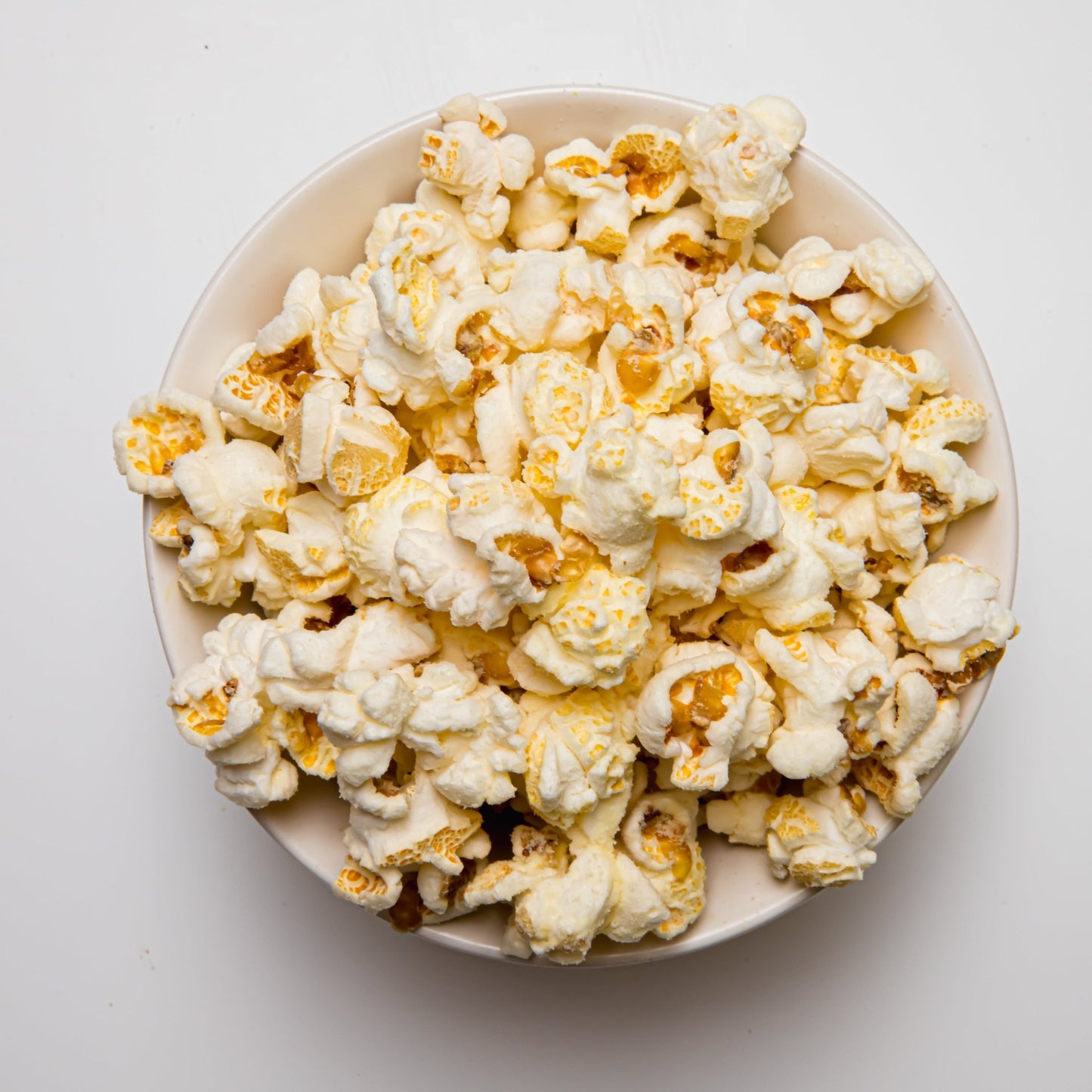 White cheddar popcorn from Colorado Popcorn Company, showing a close-up of fluffy, cheesy-coated popcorn kernels.