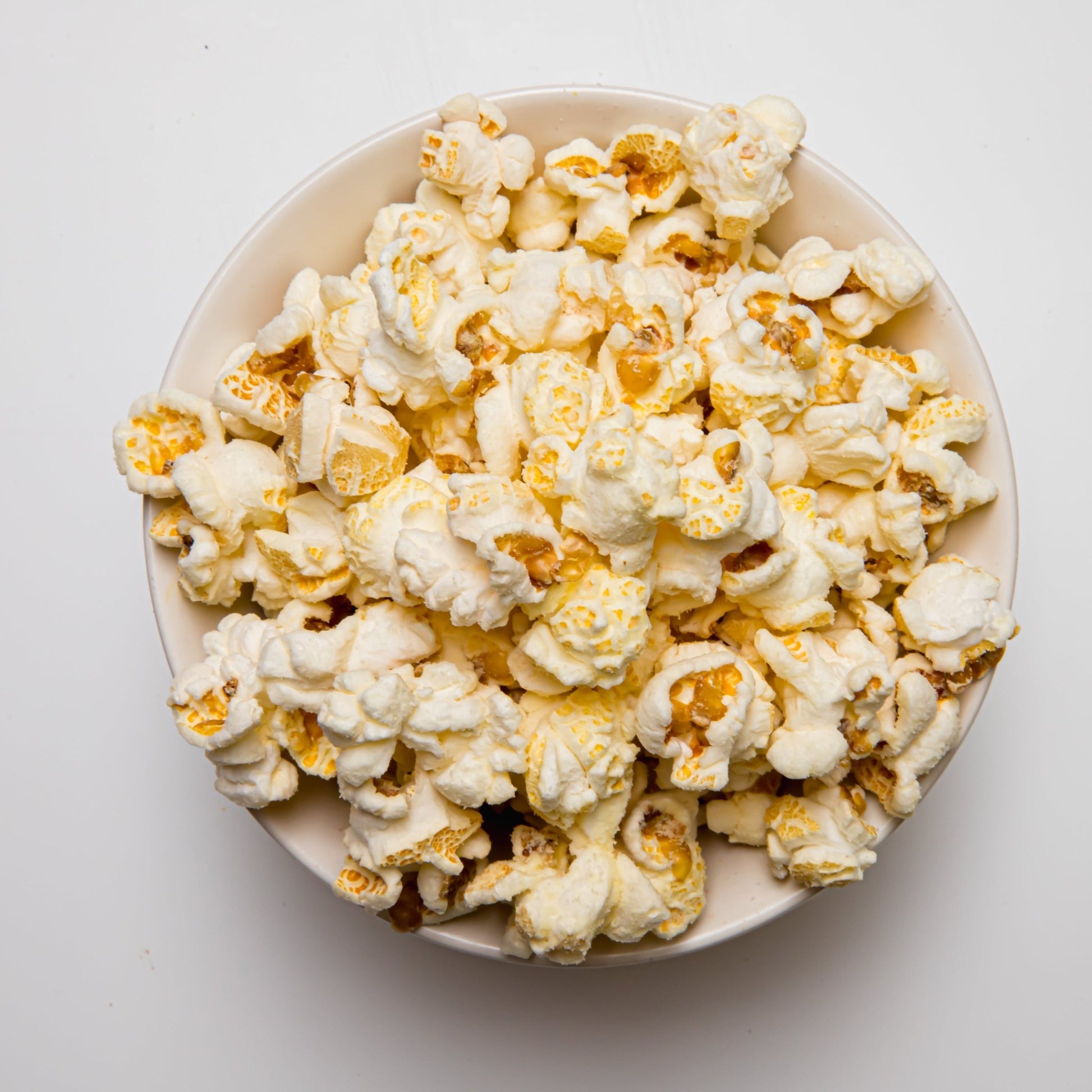 White cheddar popcorn from Colorado Popcorn Company, showing a close-up of fluffy, cheesy-coated popcorn kernels.