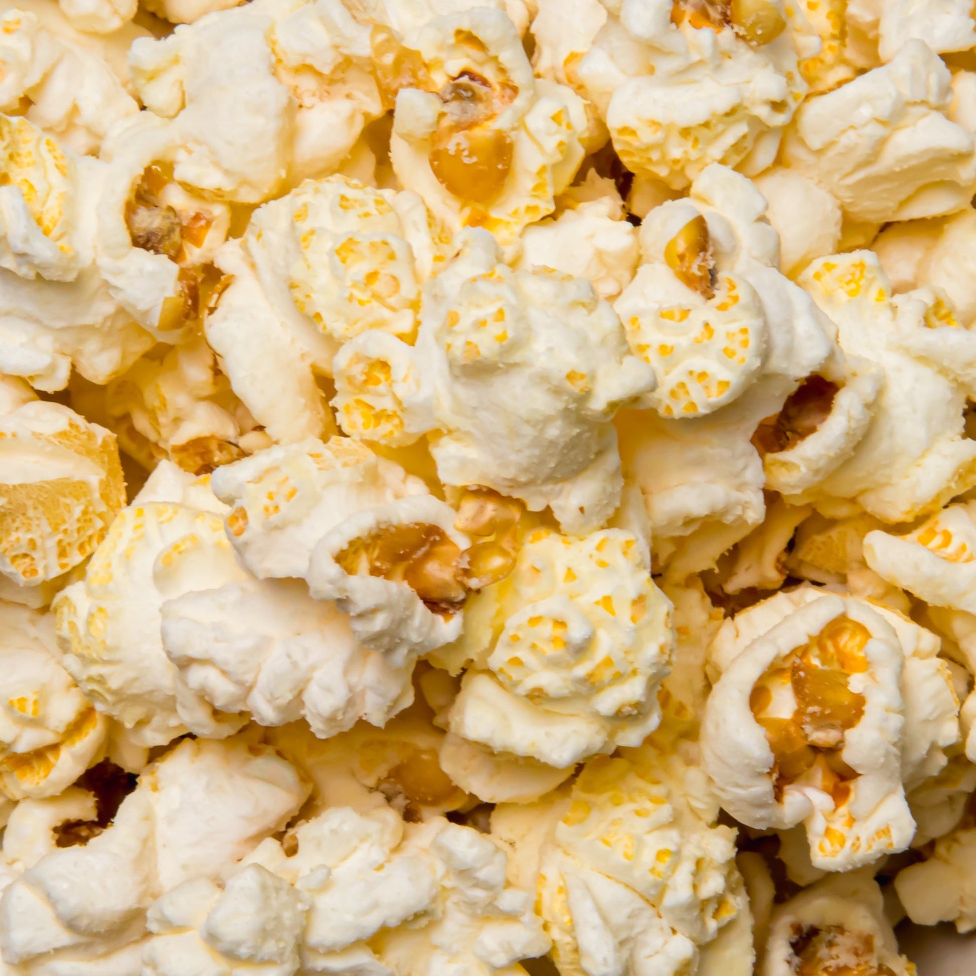 White cheddar popcorn by Colorado Popcorn Company in a 2 oz bag, crispy, cheesy snack with golden white cheddar coating.