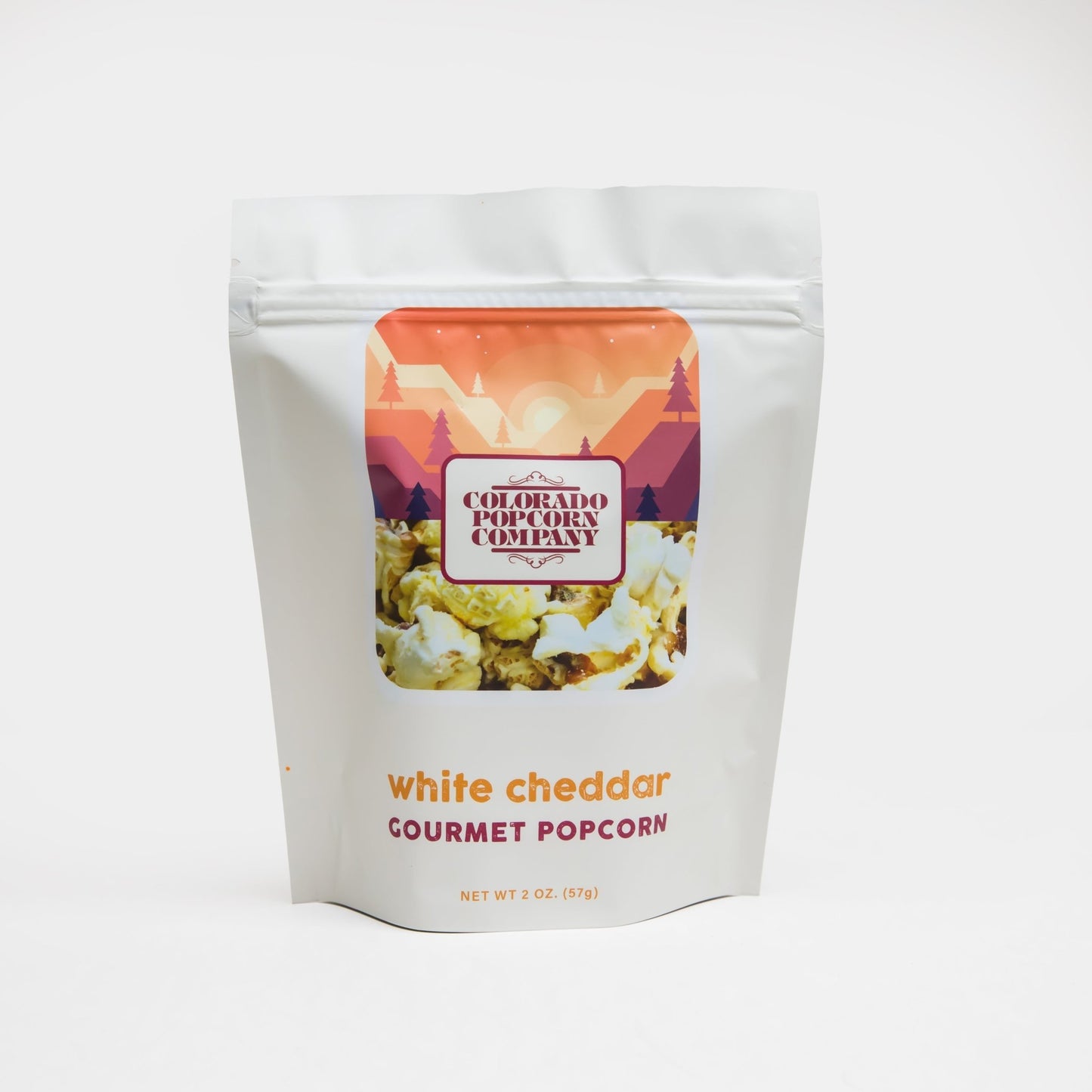 White Cheddar Popcorn by Colorado Popcorn Company in a 2 oz bag, showing fluffy popcorn coated with white cheddar cheese.