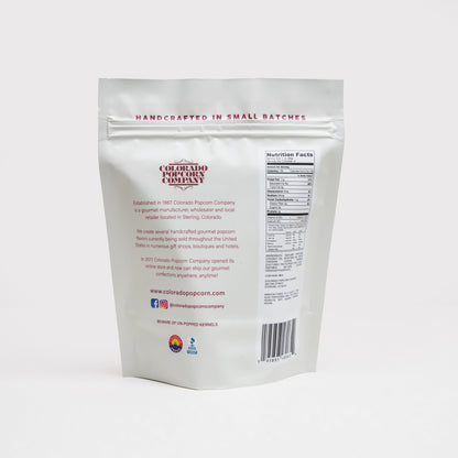 White cheddar popcorn by Colorado Popcorn Company in a 2 oz bag, showing golden popcorn coated with white cheddar seasoning.