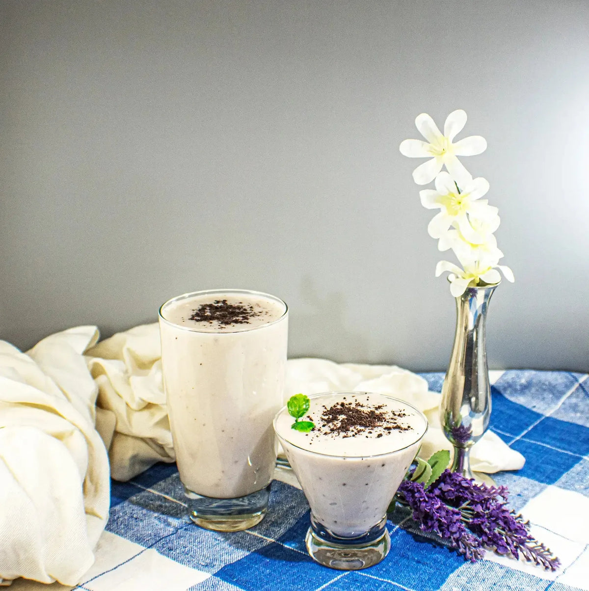 Creamy Cookie Shake from AmBari Nutrition in a glass, topped with whipped cream and cookie crumbles, served as a delicious milkshake.