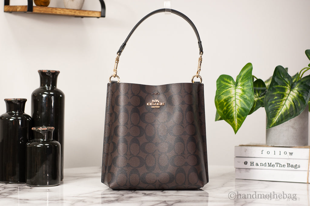 Coach Mollie 22 small brown and black coated canvas bucket crossbody handbag with adjustable strap and interior pocket.