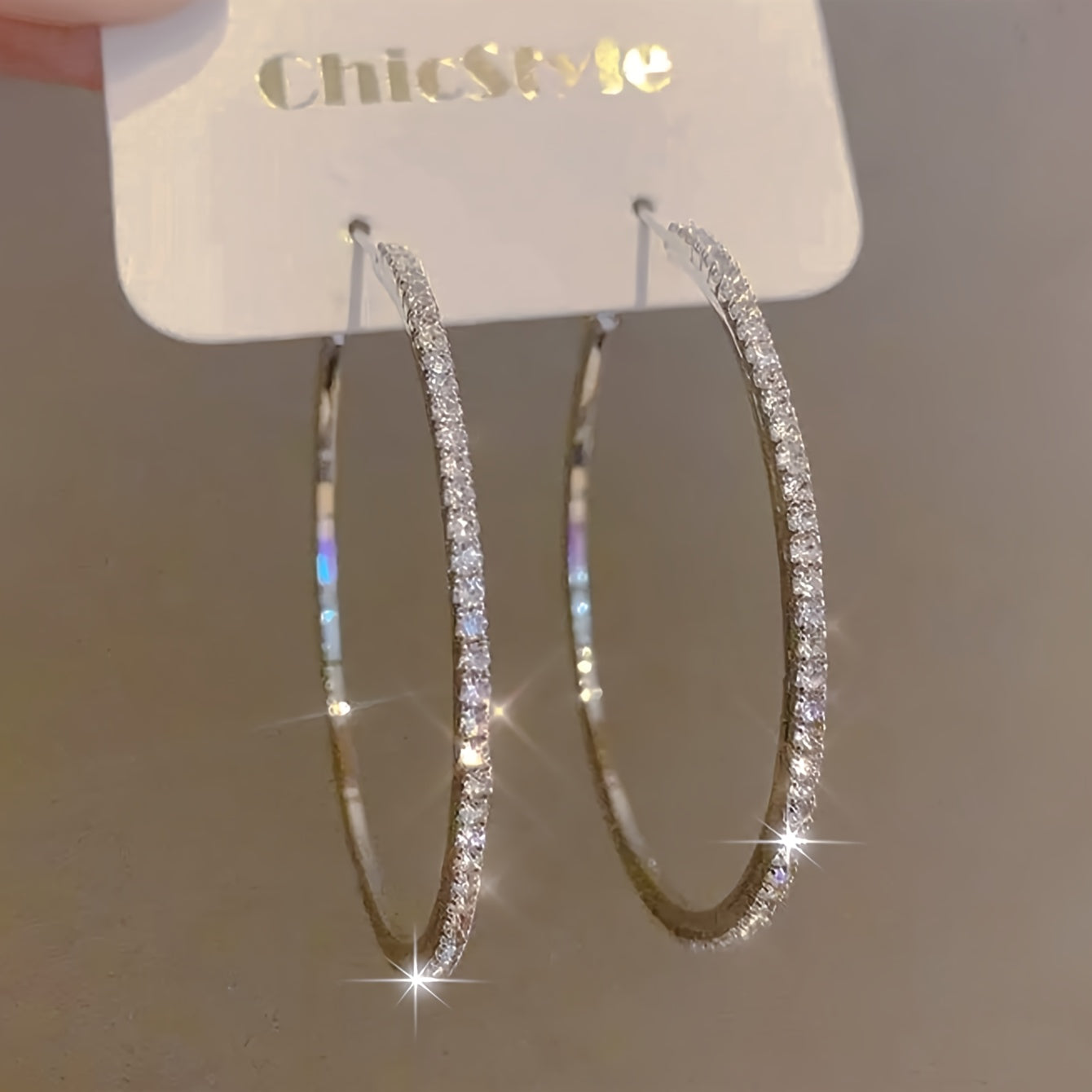 Large gold stainless steel women's rhinestone hoop earrings with sparkling bling design, showcasing their bold, elegant style.