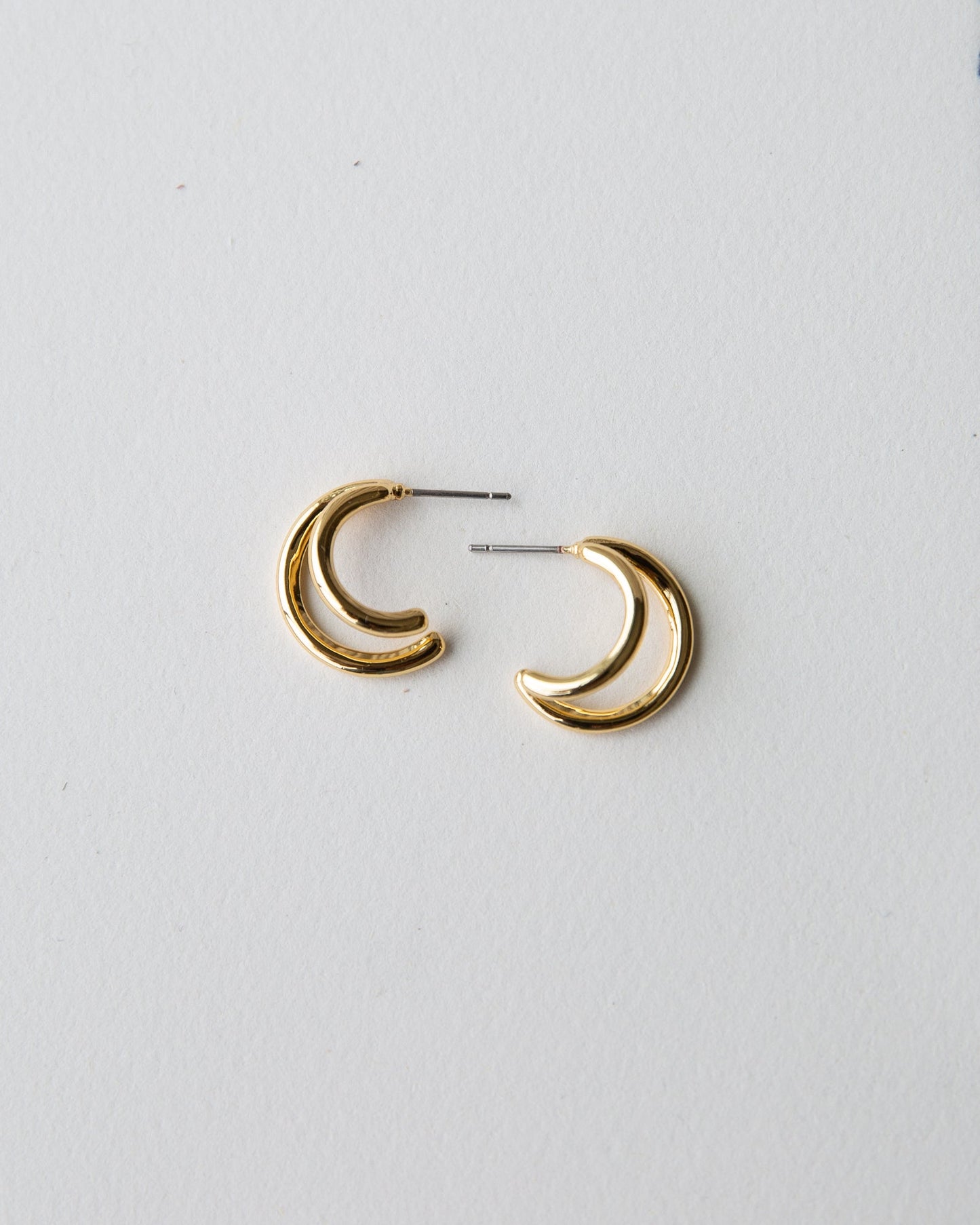 Gold double hoop earrings by Downeast, stylish jewelry featuring two interconnected hoops for a chic look.
