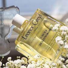 Leonor Greyl L'Huile de Leonor Greyl pre-shampoo treatment oil in a 3.2 oz bottle, shown with a pump dispenser and hair in the background.