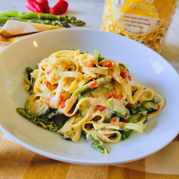 Al Dente Pasta Egg Fettuccine by Duo Grocery, uncooked pasta strands with a golden yellow color on a white background.