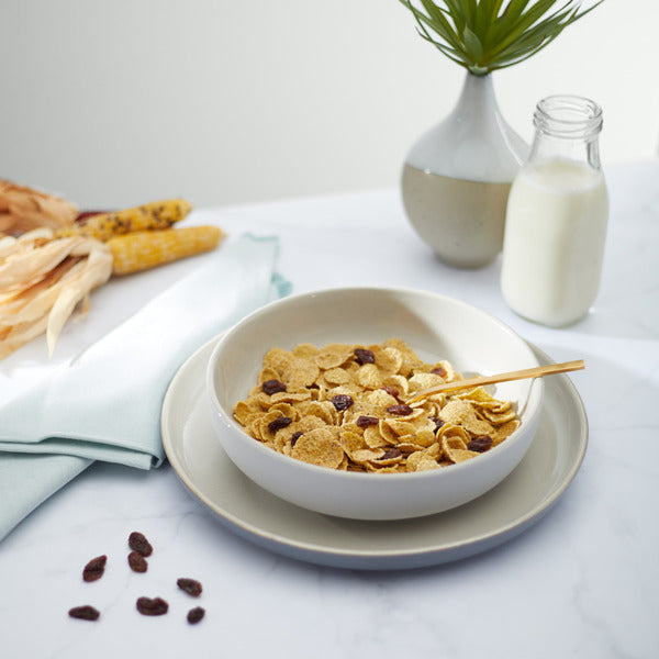 Bowl of Nature's Path Mesa Sunrise cereal with raisins on a plate, showing toasted grains and dried raisins.