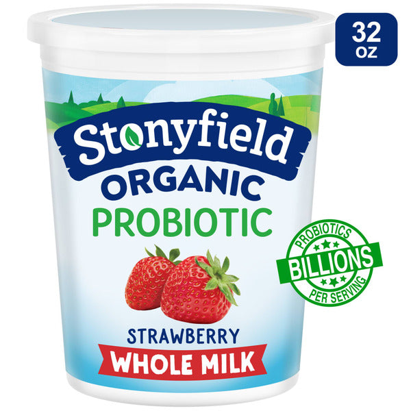 Stonyfield Organic Strawberry Whole Milk Probiotic Yogurt in a cup with fresh strawberries and yogurt swirls on top.