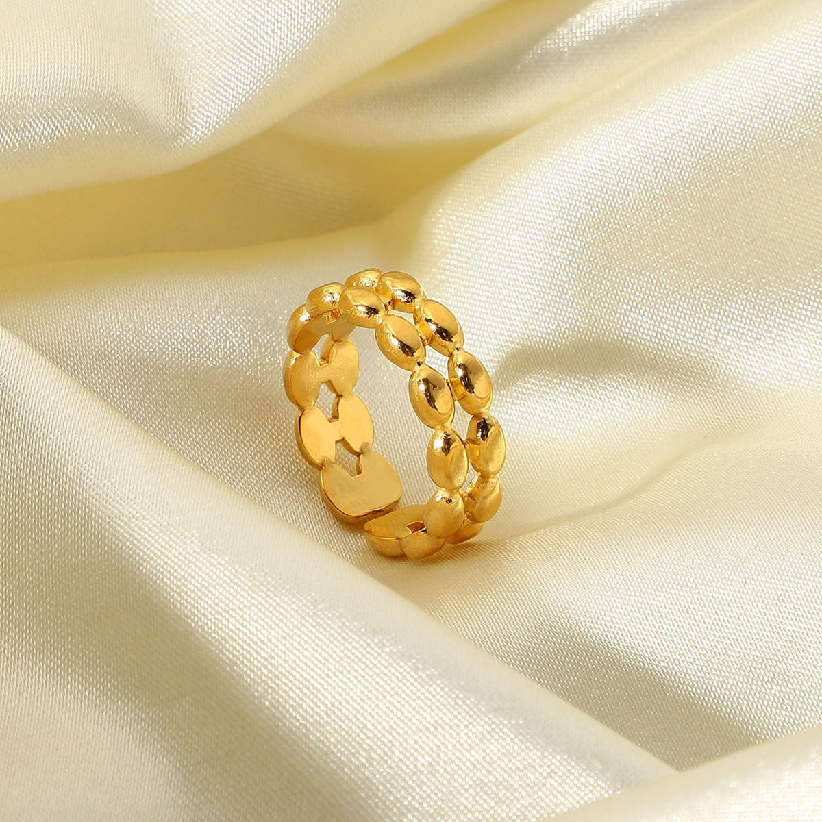 Maggie gold ring, delicate gold band with a polished finish against a plain background