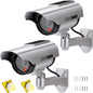 Two silver solar-powered dummy security cameras with red LED lights and CCTV stickers, designed for indoor and outdoor surveillance.