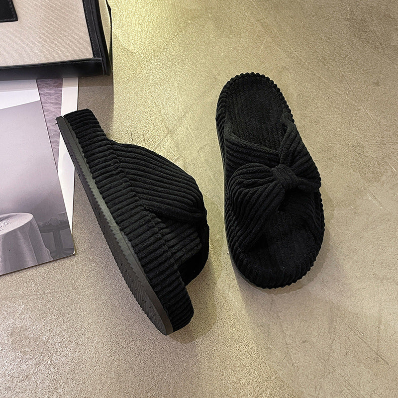 Women's cross-strap flat slide sandals in a simple open-toe design, shown in neutral tones