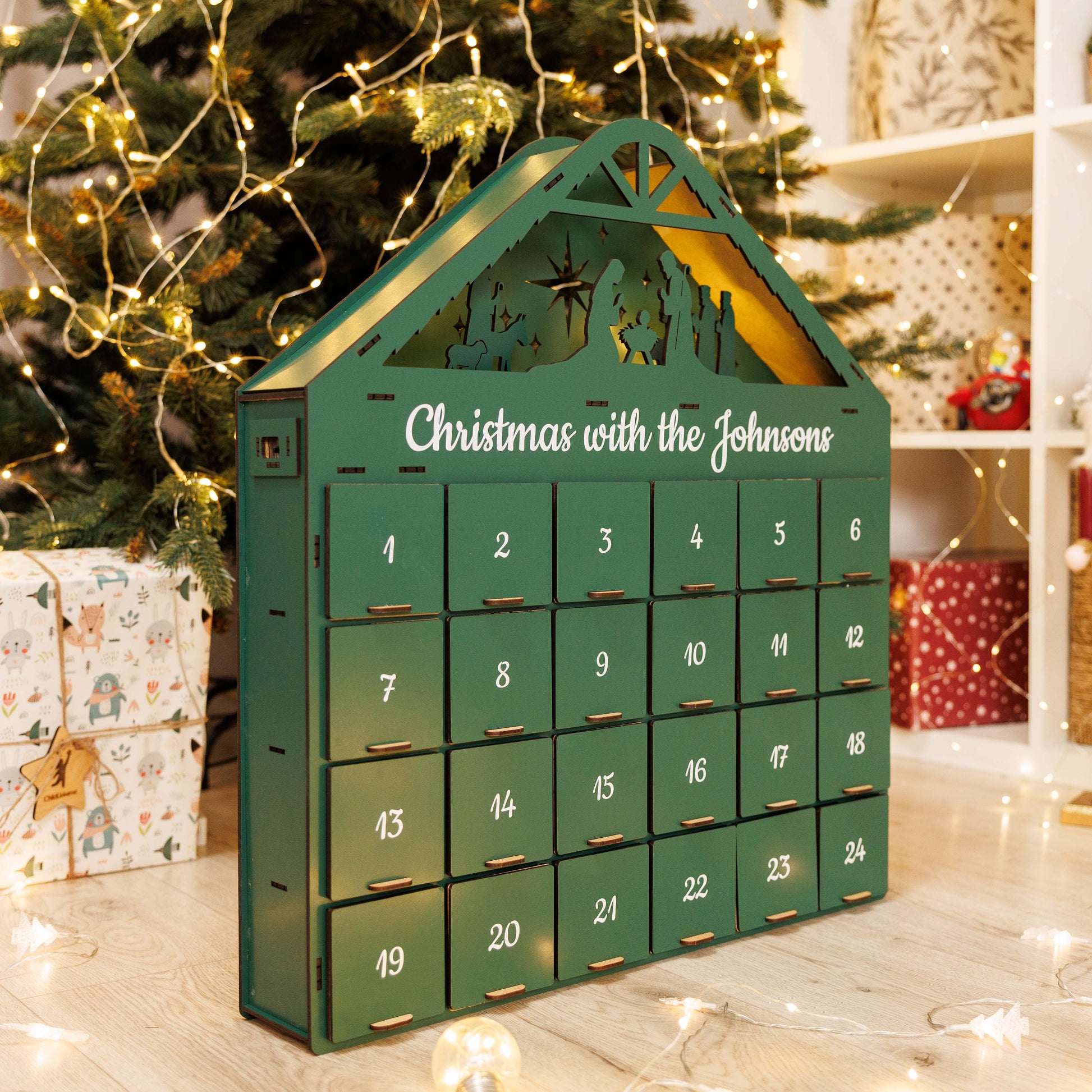 Green Christmas Advent Calendar by Enjoy The Wood, showcasing numbered doors and festive holiday design.