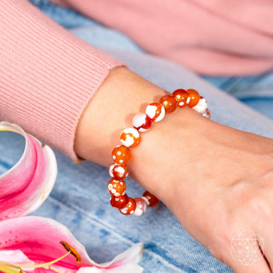 Feminine Force Carnelian Orca Agate bracelet by Conscious Items featuring vibrant orange and black patterned stone beads.