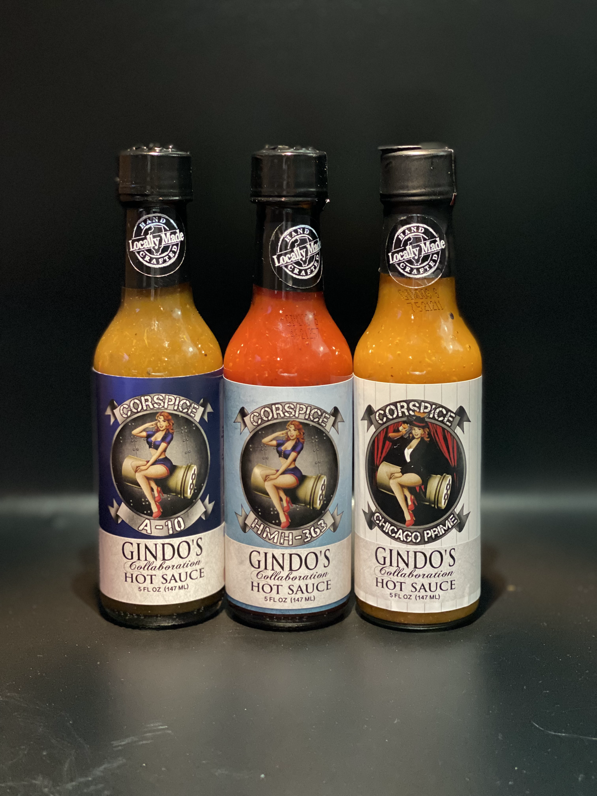 Three bottles of Corspice hot sauce in a 3-pack, featuring vibrant labels and spicy flavors in clear glass bottles.