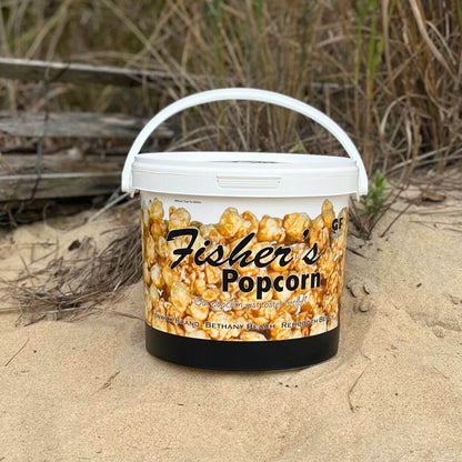 Fisher's Popcorn caramel popcorn tub, 1.2-gallon size, featuring a colorful design and a generous serving of freshly popped caramel popcorn.