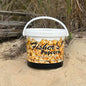 Fisher's Popcorn caramel popcorn tub, 1.2-gallon size, featuring a colorful design and a generous serving of freshly popped caramel popcorn.