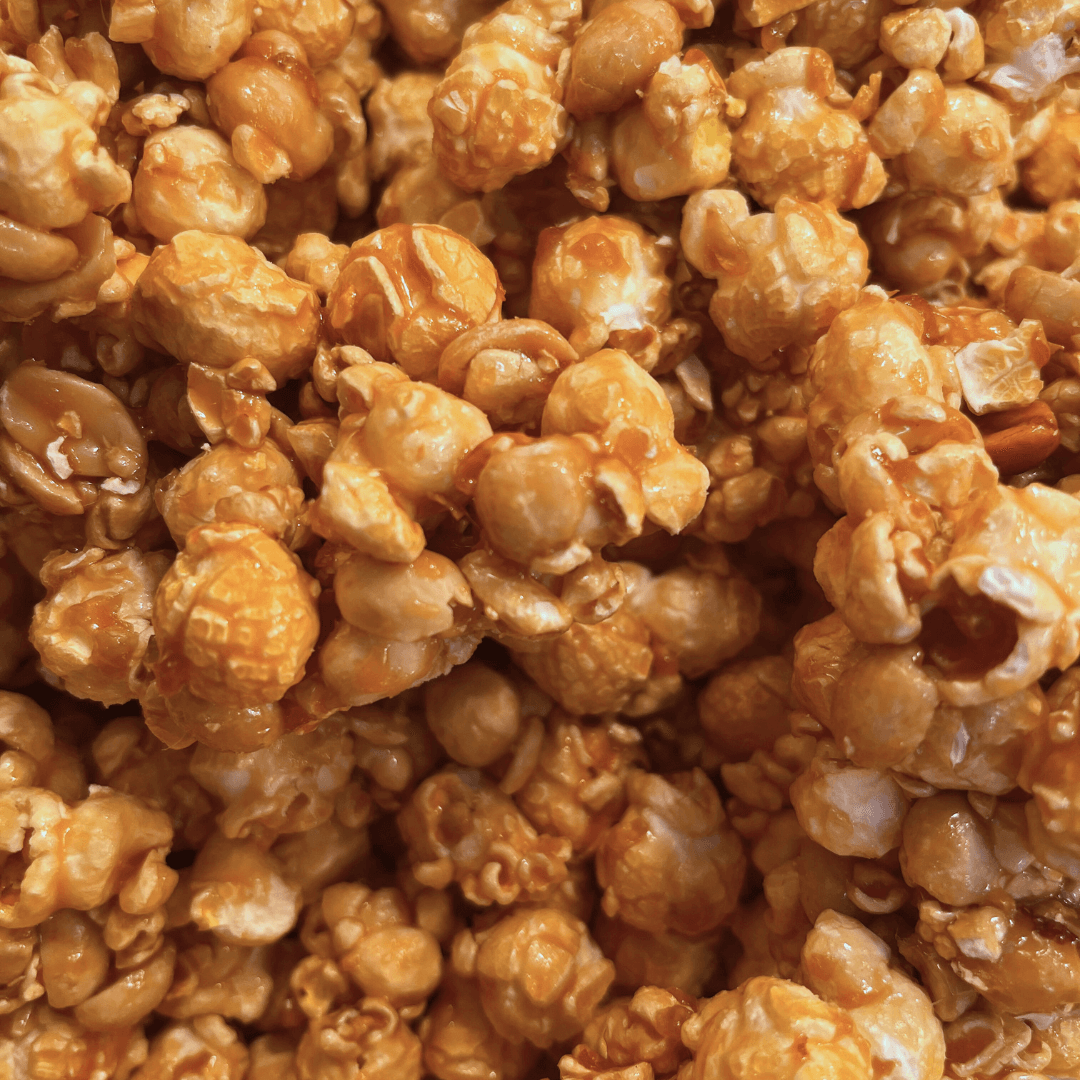 Fisher's Popcorn caramel popcorn tub, 1.2 gallons, in a large, clear plastic container with Fisher's branding on the label.